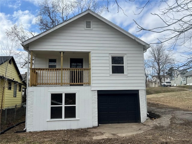 back of property with brick siding and a garage