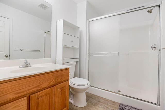 full bath with visible vents, toilet, a stall shower, and vanity