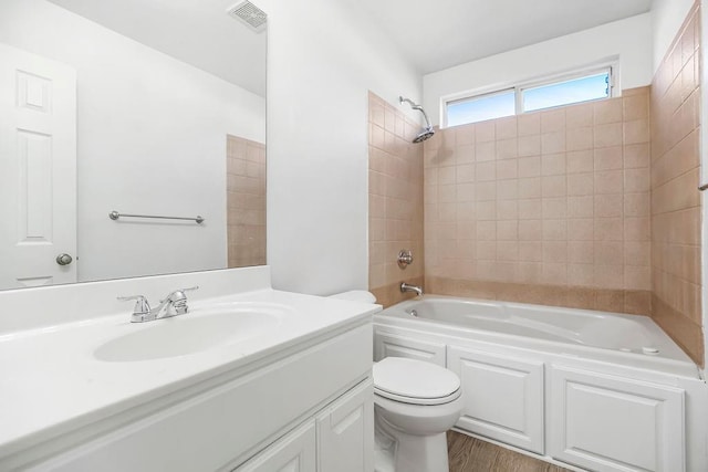 full bathroom featuring visible vents, toilet, wood finished floors, bathing tub / shower combination, and vanity