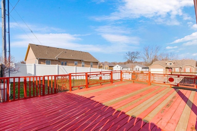 wooden terrace featuring a residential view and a fenced backyard