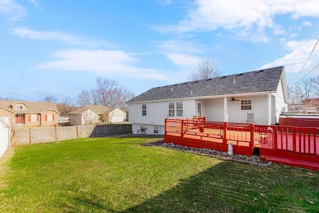 rear view of property with roof with shingles, a lawn, a fenced backyard, and a wooden deck