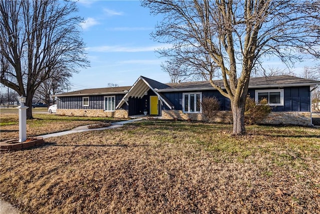 ranch-style house with board and batten siding and a front lawn