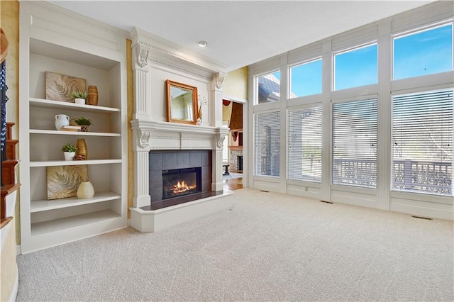 unfurnished living room featuring carpet flooring, a fireplace, plenty of natural light, and built in features