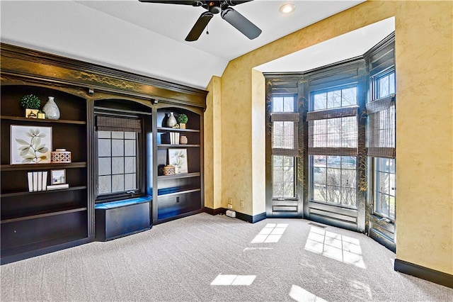 spare room featuring a ceiling fan, baseboards, vaulted ceiling, carpet flooring, and a textured wall