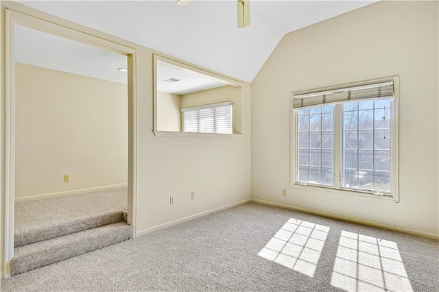 carpeted spare room with visible vents, ceiling fan, baseboards, and lofted ceiling