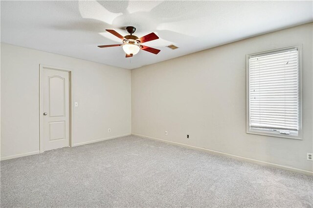 empty room with baseboards, a ceiling fan, and carpet