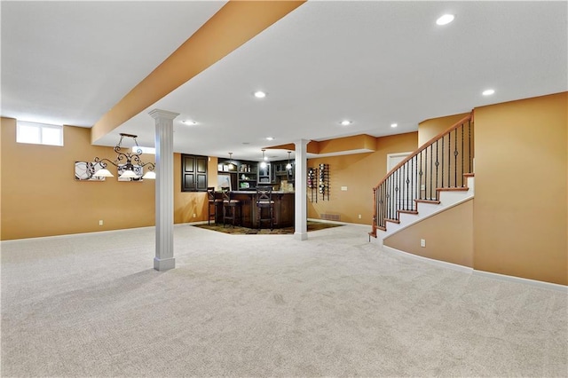 unfurnished living room featuring recessed lighting, carpet, decorative columns, baseboards, and indoor bar