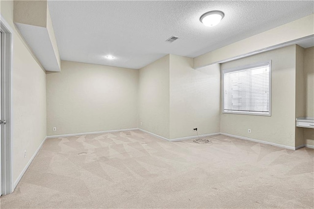 interior space with baseboards, visible vents, and a textured ceiling