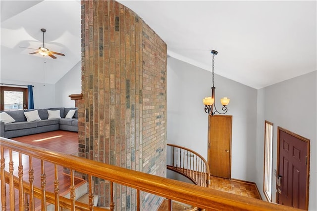 staircase with parquet floors, ceiling fan with notable chandelier, and high vaulted ceiling