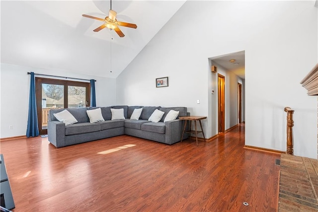 living area featuring baseboards, wood finished floors, high vaulted ceiling, and ceiling fan