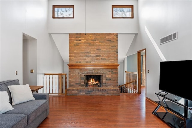 living area featuring a wealth of natural light, visible vents, and wood finished floors