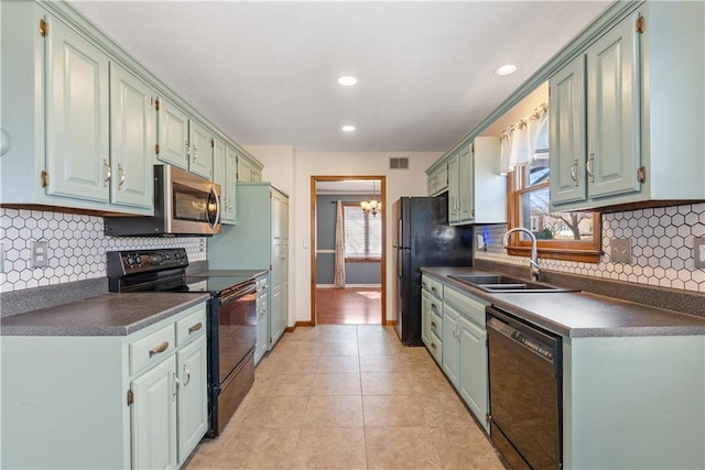 kitchen with black appliances, light tile patterned floors, dark countertops, and a sink