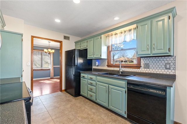 kitchen featuring a sink, visible vents, dark countertops, and black appliances