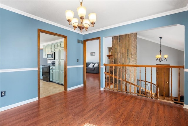 empty room featuring visible vents, an inviting chandelier, wood finished floors, and ornamental molding