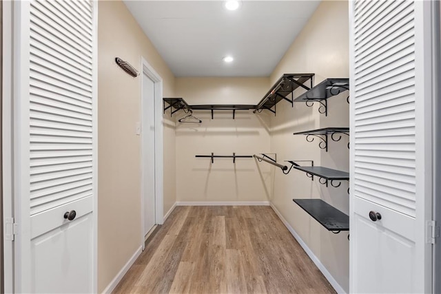 walk in closet with light wood-style floors