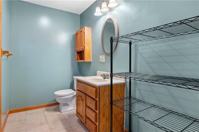 bathroom with tile patterned floors, toilet, vanity, and baseboards