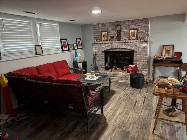 living room with a fireplace, wood finished floors, and visible vents