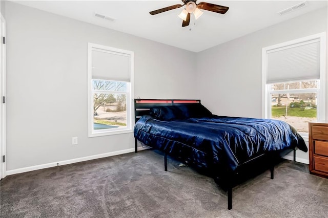 carpeted bedroom featuring visible vents, multiple windows, and baseboards