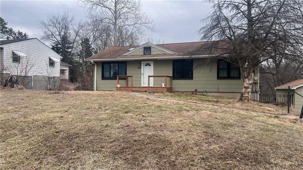 view of front of home with a front yard and fence