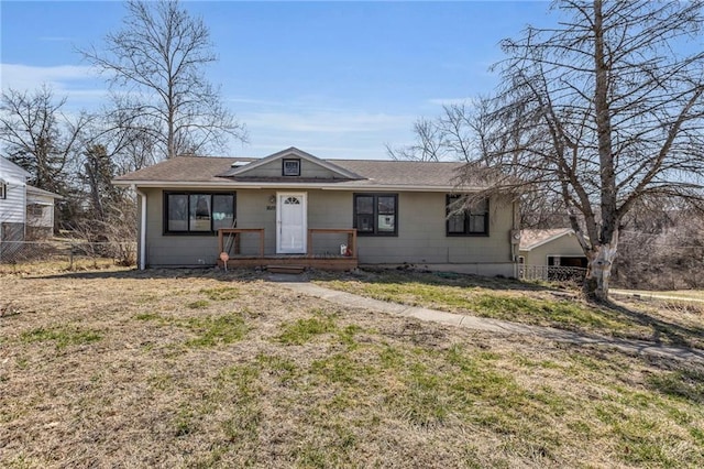 view of front of property with roof with shingles, a front yard, and fence