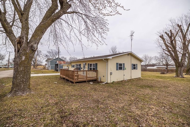 back of property with a wooden deck and a yard