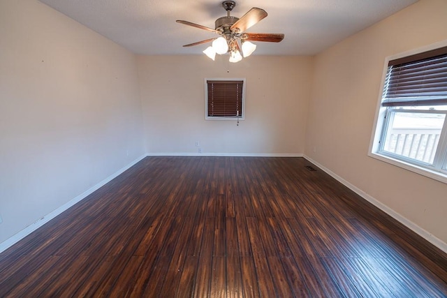 unfurnished room featuring visible vents, baseboards, wood finished floors, and a ceiling fan