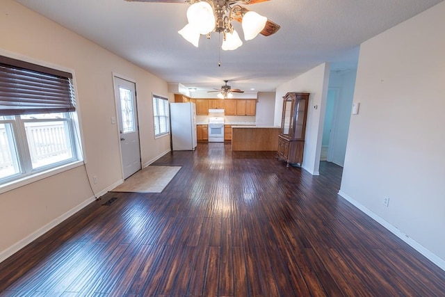 kitchen with white appliances, baseboards, visible vents, dark wood-style flooring, and light countertops