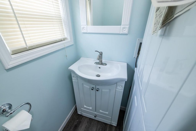 bathroom featuring baseboards, wood finished floors, and vanity