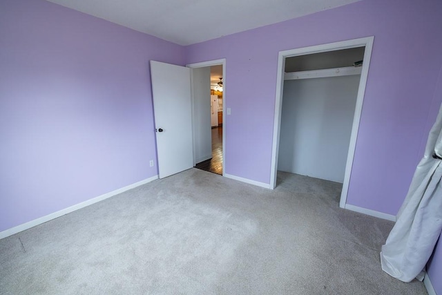 unfurnished bedroom with baseboards, carpet floors, and a closet