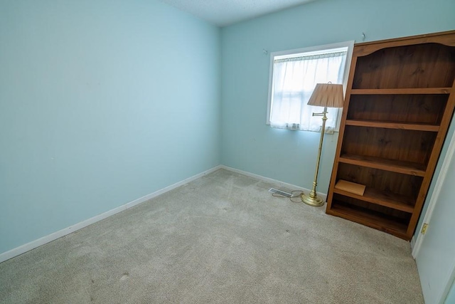 unfurnished room featuring carpet flooring and baseboards