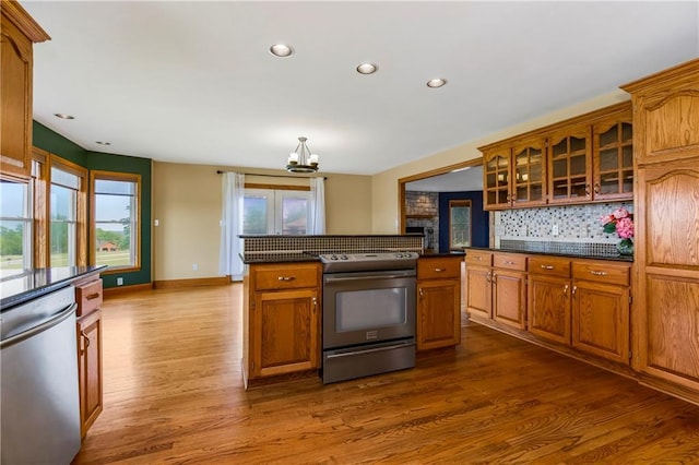 1796 NW 770th Rd, Bates City, MO 64011 - kitchen featuring appliances with stainless steel finishes, dark countertops, a chandelier, dark wood-type flooring, and decorative backsplash