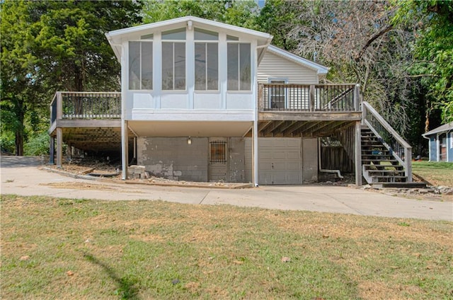 exterior space featuring an attached garage, stairs, a deck, and a sunroom