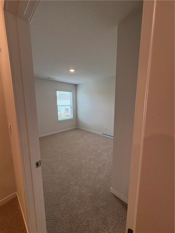 carpeted empty room featuring recessed lighting and baseboards