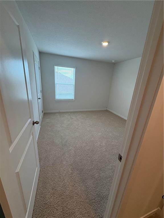 carpeted empty room with baseboards