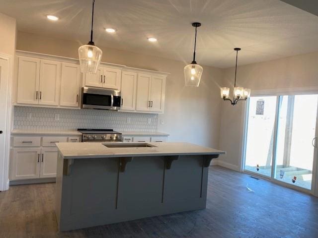 kitchen featuring white cabinetry, decorative backsplash, appliances with stainless steel finishes, and a center island