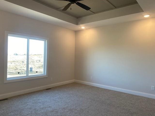 carpeted spare room featuring a tray ceiling, recessed lighting, baseboards, and ceiling fan