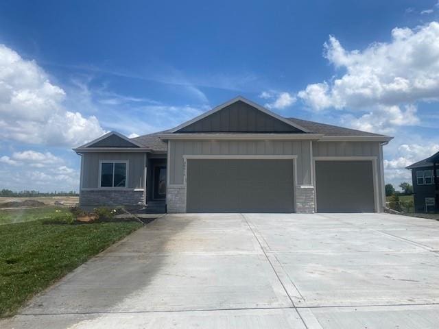 20814 W 188th St, Spring Hill, KS 66083 - view of front of home with an attached garage, board and batten siding, concrete driveway, and stone siding