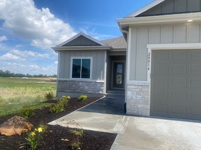 20814 W 188th St, Spring Hill, KS 66083 - doorway to property with stone siding, board and batten siding, and a garage