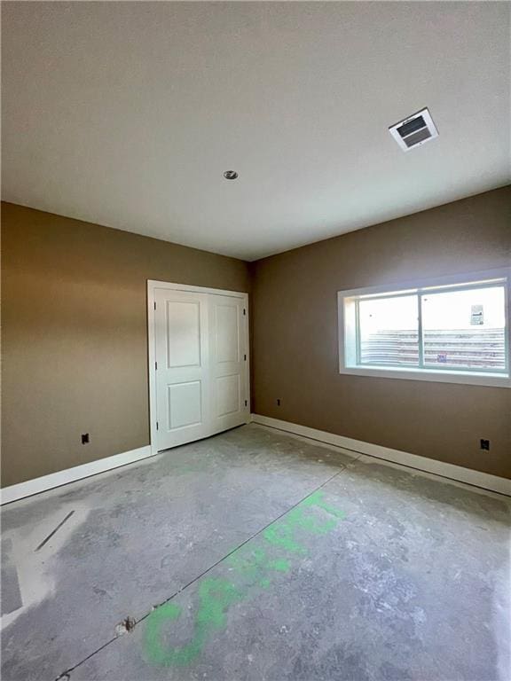 1302 NE 122nd St, Kansas City, MO 64165 - unfurnished bedroom featuring baseboards, concrete floors, and a closet