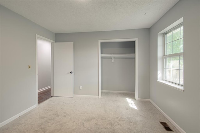 unfurnished bedroom with baseboards, visible vents, carpet floors, and a textured ceiling