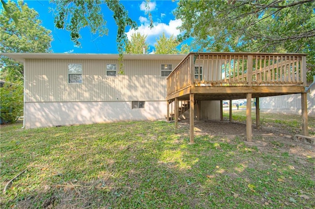 back of property with a deck, stairway, and a yard