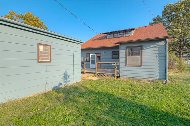 rear view of house featuring a yard and a wooden deck