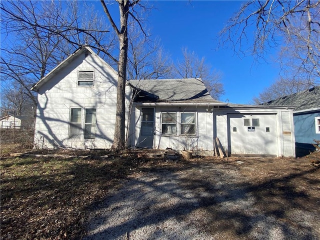 view of front of home with an attached garage and dirt driveway