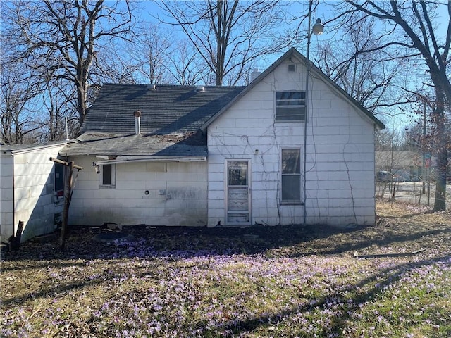 rear view of house with a shingled roof