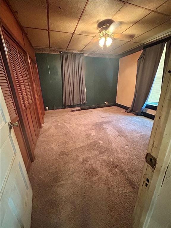 unfurnished bedroom featuring a drop ceiling, visible vents, and carpet