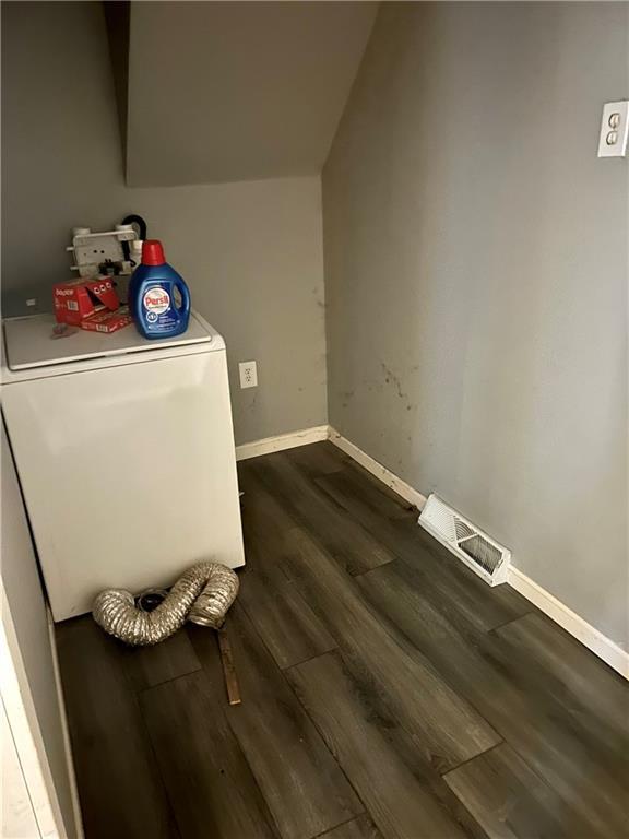 laundry room with visible vents, laundry area, baseboards, washer / dryer, and dark wood-style flooring