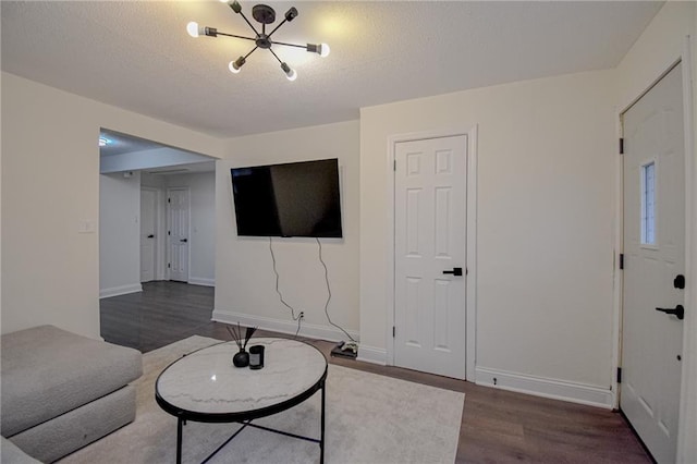 living room with wood finished floors, baseboards, and a textured ceiling