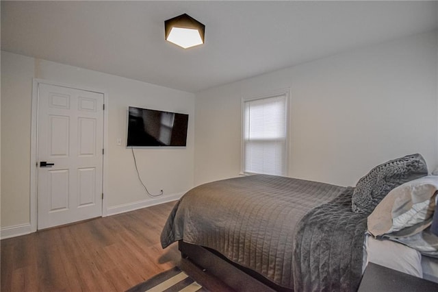 bedroom featuring baseboards and wood finished floors