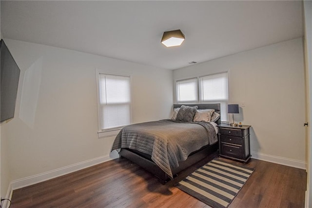 bedroom with visible vents, baseboards, and dark wood-style floors