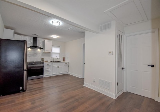 kitchen featuring visible vents, stainless steel appliances, wall chimney exhaust hood, and light countertops